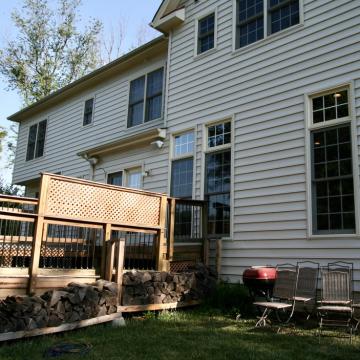 Back of house with raised wood deck and lawn seating