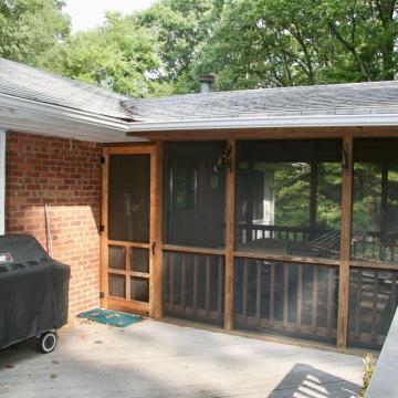 Existing screened porch beside brick patio with covered grill
