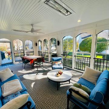 Bright three season room with blue seating and arched windows