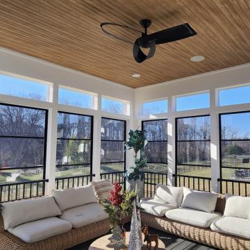 Bright three season room with screened windows and wood ceiling