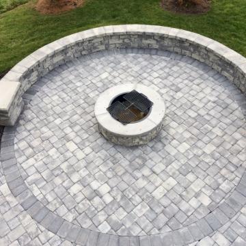 Circular stone fire pit patio with curved seating wall