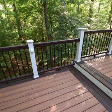 Composite deck with dark railings overlooking a wooded backyard