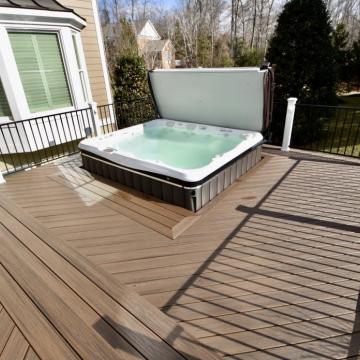 Composite deck with hot tub and black metal railing