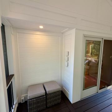 Covered deck corner with shiplap wall and sliding glass door