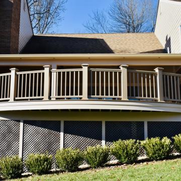 Covered elevated deck with curved front railing and lattice skirting