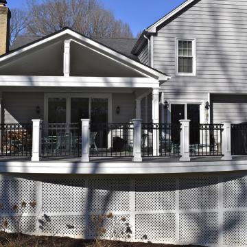 Covered open-air porch with white columns and black railing