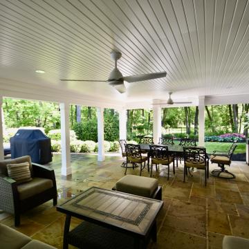 Covered patio deck with ceiling fans, dining set, and grill
