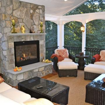 Covered patio seating area with tall stone fireplace