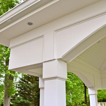 Covered porch roof with white columns and decorative curved brackets