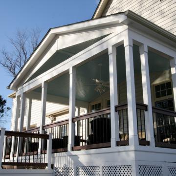 Covered rear porch with white columns and dark railings