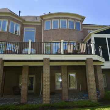 Elevated rear deck and screened porch on large brick home