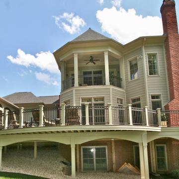 Elevated screened porch and curved deck on large rear exterior