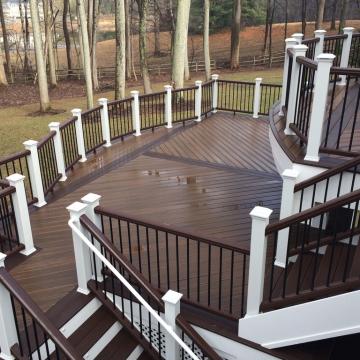 Multi-level curved deck with white posts and dark railings