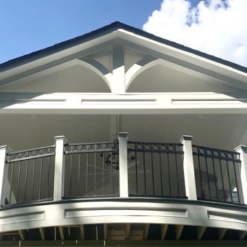 Open air porch with curved black railing and gabled roof