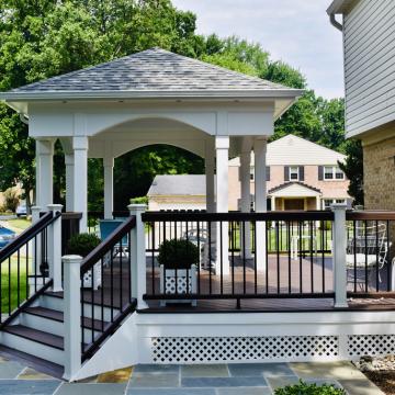 Open air porch with hipped roof, steps, and black railings