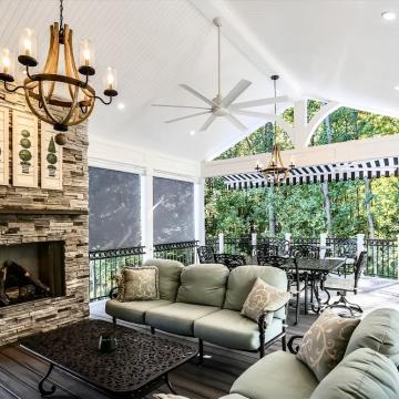 Open air porch with stone fireplace, vaulted ceiling, and seating