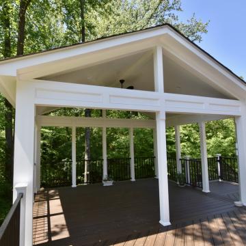 Open air porch with white gabled roof and deck railing