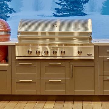 Built-in outdoor kitchen with stainless grill and red ceramic smoker