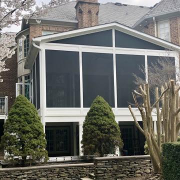 Rear elevated screen porch with white framing and dark mesh panels