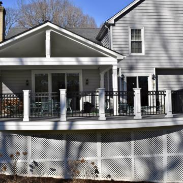 Rear view of home with covered deck and white lattice