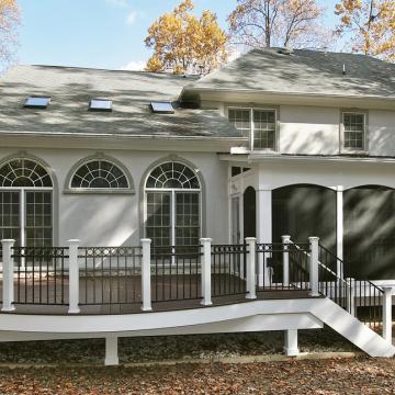 Rear home exterior with elevated deck and screened porch addition