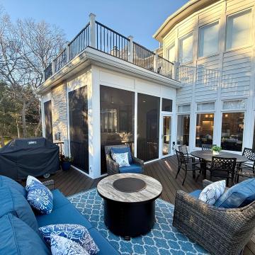 Screen porch addition with upper deck and adjacent outdoor seating