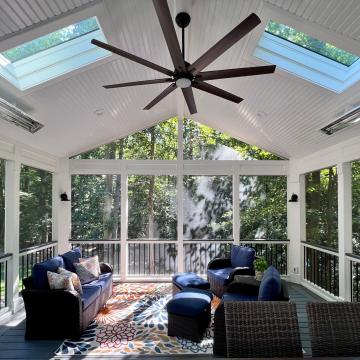 Screen porch interior with skylights, ceiling fan, and wicker seating