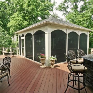 Screened porch pavilion on large deck with outdoor dining furniture