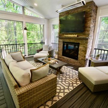 Screened porch seating area with stone fireplace and mounted TV