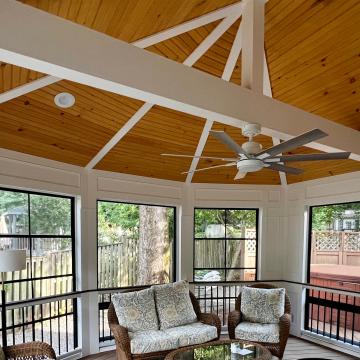 Screened porch with wood vaulted ceiling, beams, and ceiling fan