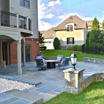 Stone patio with seating area and curved retaining wall
