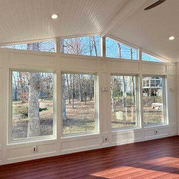 Bright three season room with large windows and vaulted beadboard ceiling