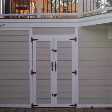 Under-deck storage doors beneath elevated deck with white trim