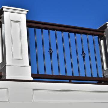 White deck railing with black metal balusters and decorative posts
