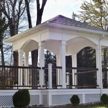 White open air porch with arched trim and dark railings