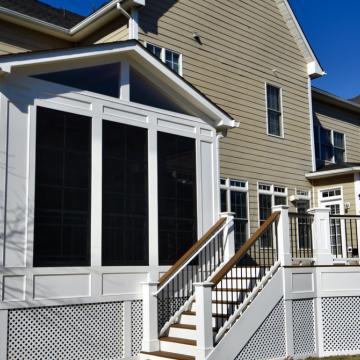 White screened porch addition with gabled roof and adjoining deck