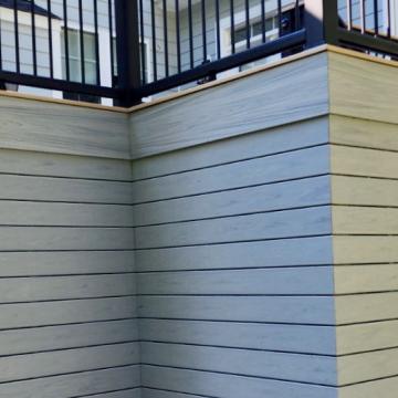 Wrapped deck skirting with black railings and side stairs