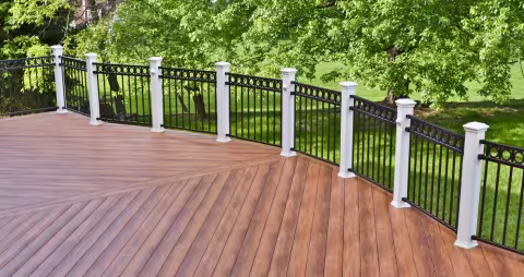 Curved wood-look deck with black metal railing and white posts