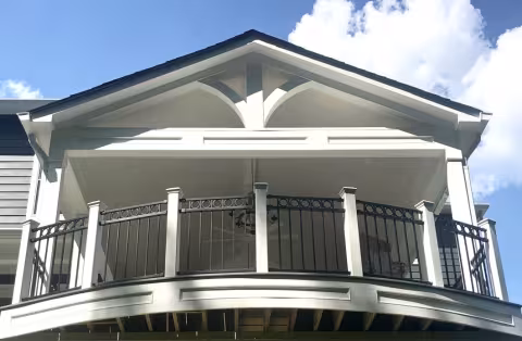 Open air porch with curved black railing and gabled roof