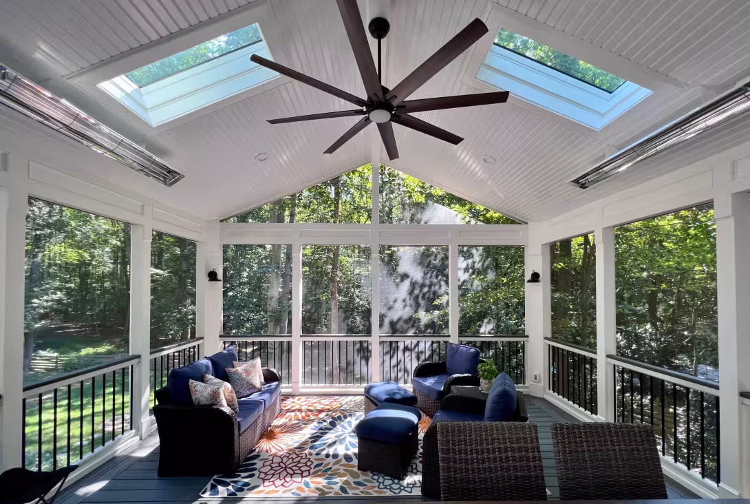 Screen porch interior with skylights, ceiling fan, and wicker seating
