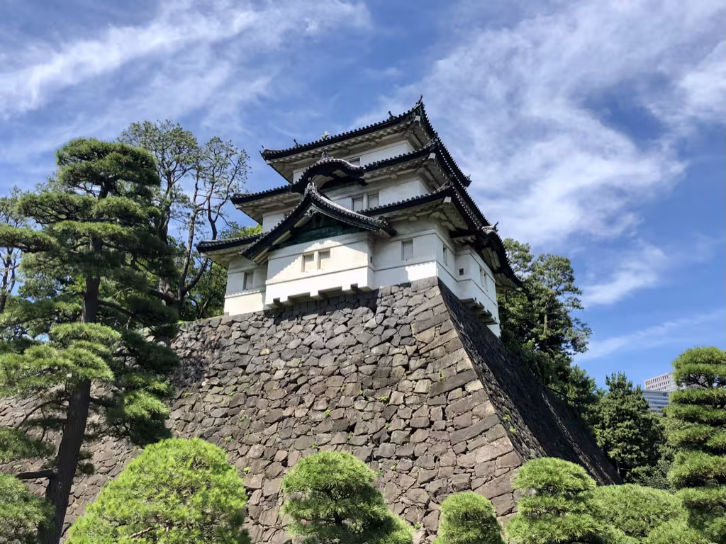 Traditional Japanese castle tower above a massive stone wall